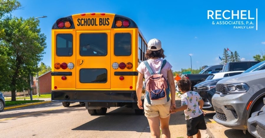 child and parent looking at school bus